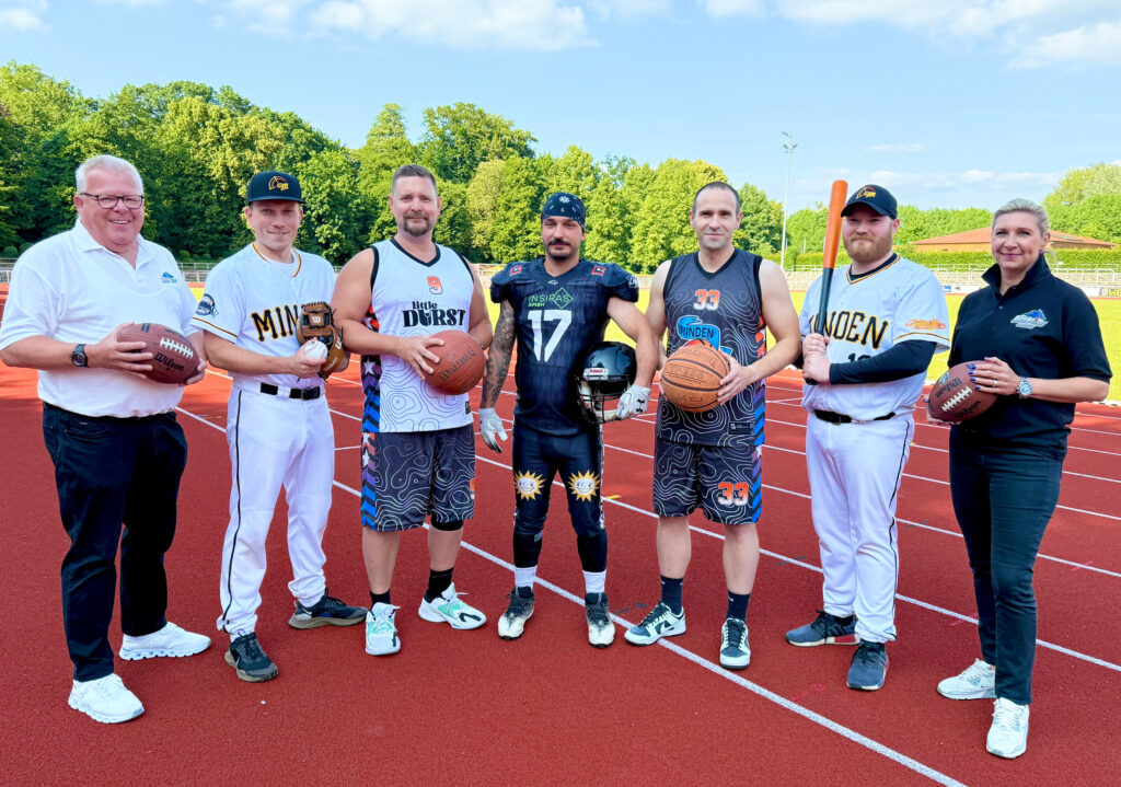 Richten am 4. Juli gemeinsam den American Sports Day aus: (v.l.n.r.) Volker Krusche (Minden Wolves), Dennis Hasfeld (Minden Millers), Ben Stumpf (Minden Movers), Guliano Schunke (Minden Wolves), Sebastian Nowak (Minden Movers), Justin Bade (Minden Millers) und Julia Fromlowitz (Minden Wolves).